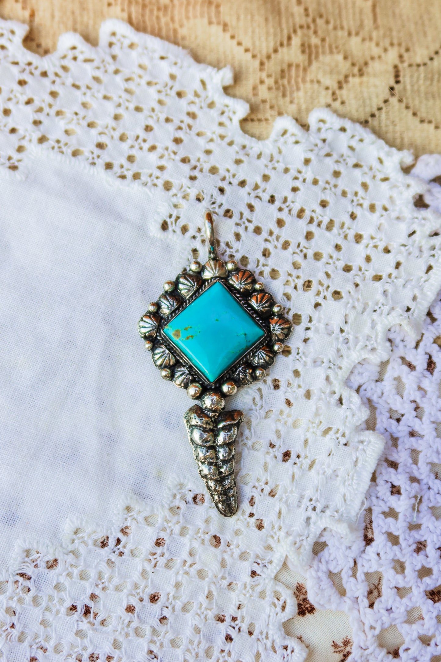 Handcrafted sterling silver pendant featuring a vibrant Kingman turquoise stone, expertly hand-stamped with intricate detailing. The design showcases a sand-cast sterling silver rattler sourced from a rattlesnake down here in south Texas. Perfect for layering or wearing as a statement pendant. 