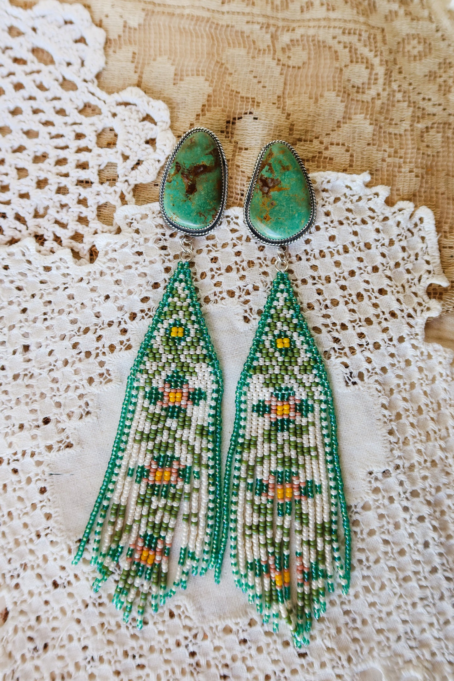 Bloom where you're beaded! These whimsical Sterling Silver and Turquoise Beaded Floral Earrings bring a touch of Southwestern charm to your everyday style. Each pair is meticulously hand-beaded with vibrant turquoise stones, creating delicate floral designs that dance with every movement. Handcrafted with love in South Texas, these earrings are a celebration of uniqueness and eccentric style. Perfect for adding a pop of color and personality to any outfit.