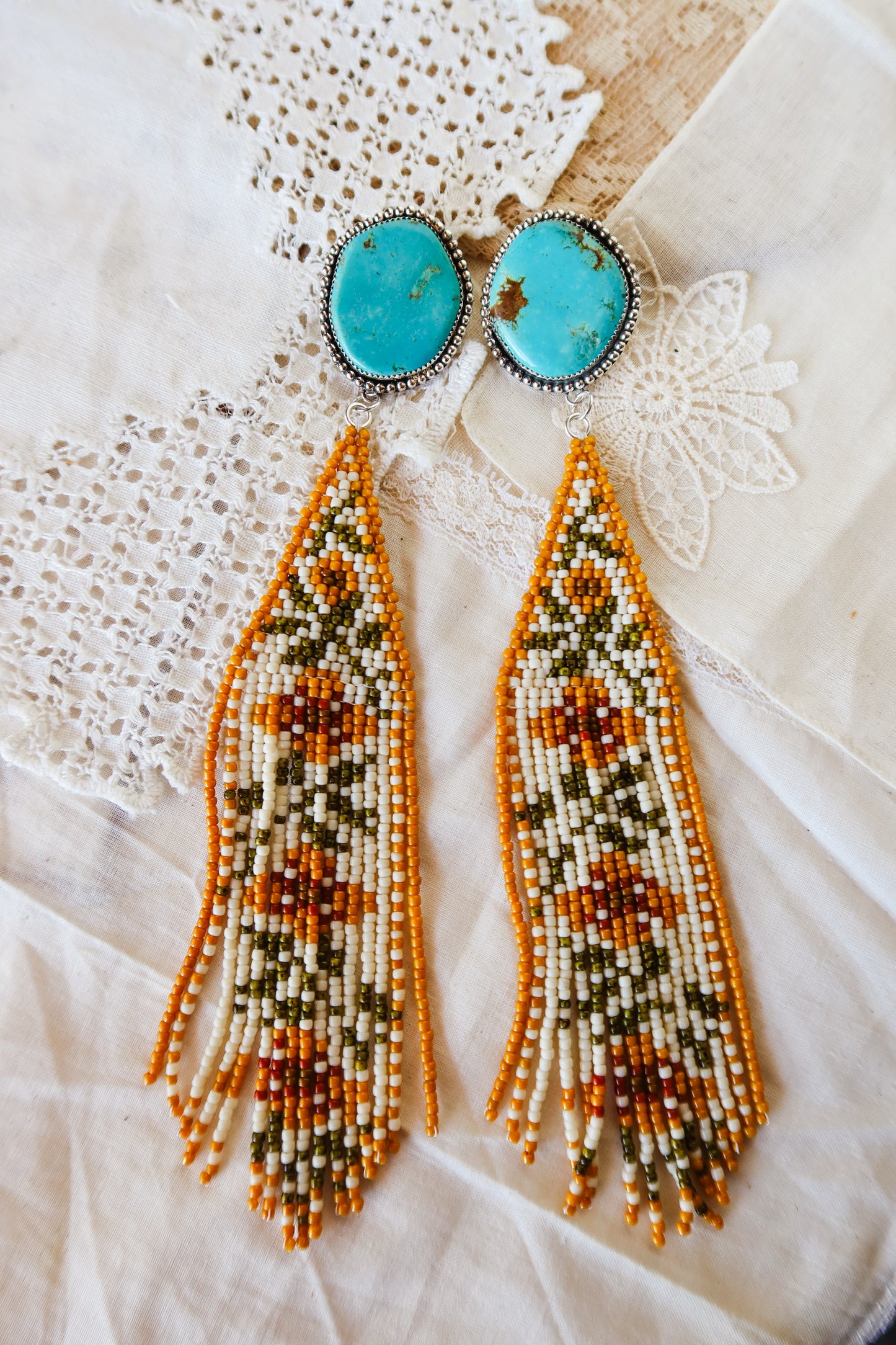 Bloom where you're beaded! These whimsical Sterling Silver and Turquoise Beaded Floral Earrings bring a touch of Southwestern charm to your everyday style. Each pair is meticulously hand-beaded with vibrant turquoise stones, creating delicate floral designs that dance with every movement. Handcrafted with love in South Texas, these earrings are a celebration of uniqueness and eccentric style. Perfect for adding a pop of color and personality to any outfit.