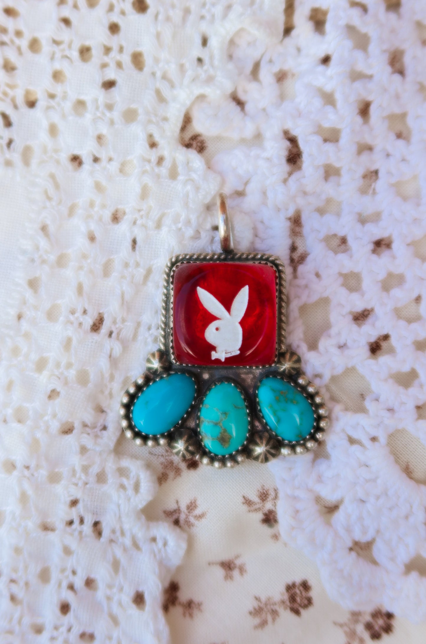 Fun Sterling Silver and Sonoran Turquoise Red Playboy Pendant. Crafted with sterling silver, this piece features vibrant Sonoran turquoise with a Red playboy dice