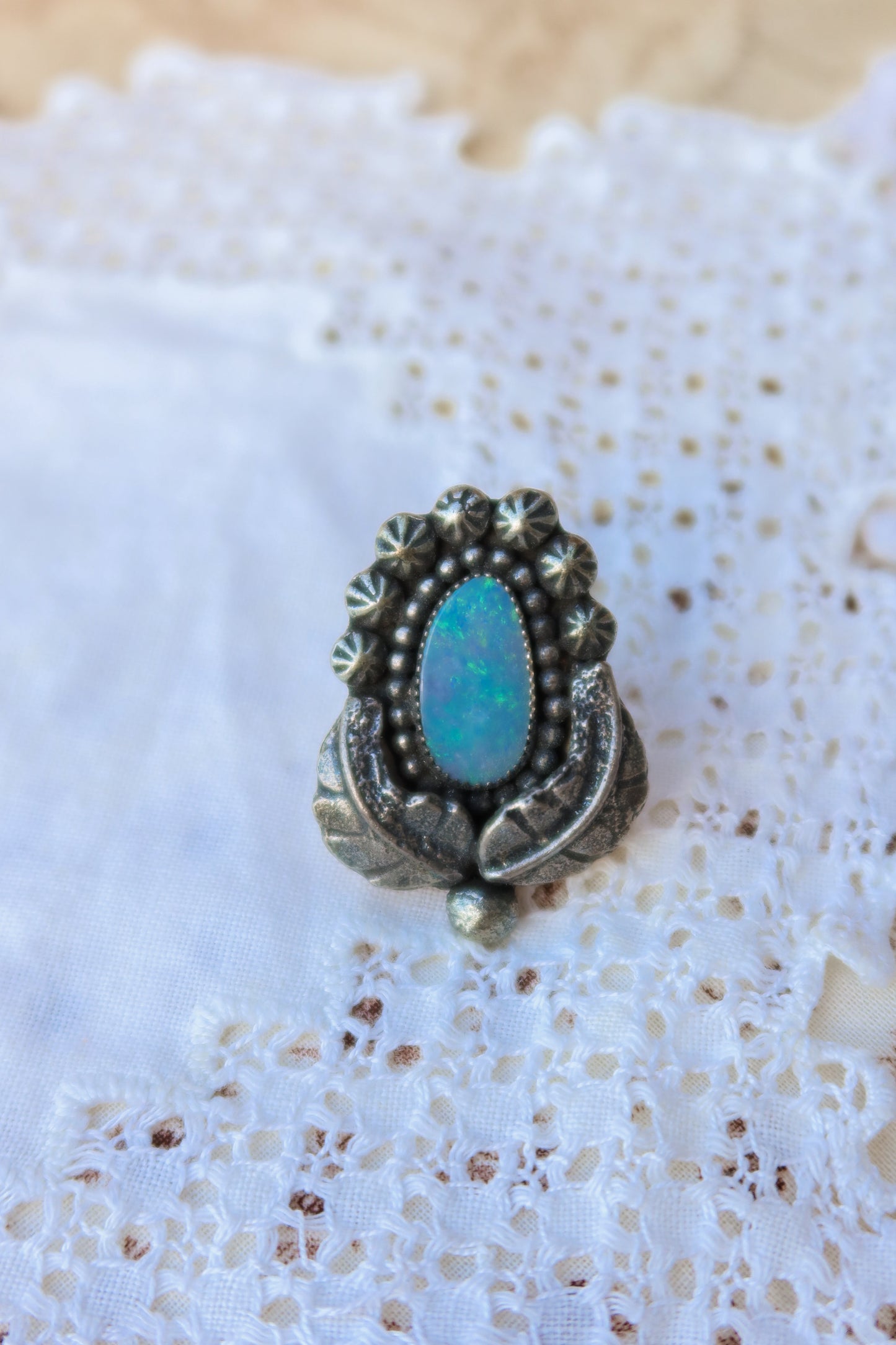 Sterling silver and genuine Australian opal ring size 6. Hand-crafted sand cast leaves frame a luminous opal center. Perfect for those who want a coastal southwestern feel!