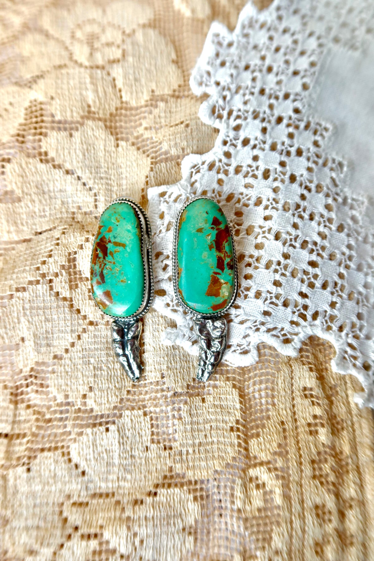 Handmade in South Texas, these sterling silver rattler earrings showcase 100% authentic Green Kingman turquoise. Sand Cast Sterling silver rattlers hang in the middle. Their unique turquoise patterns provide a subtle yet distinct accent, making your outfit stand out and give the perfect touch of uniqueness to your look! 