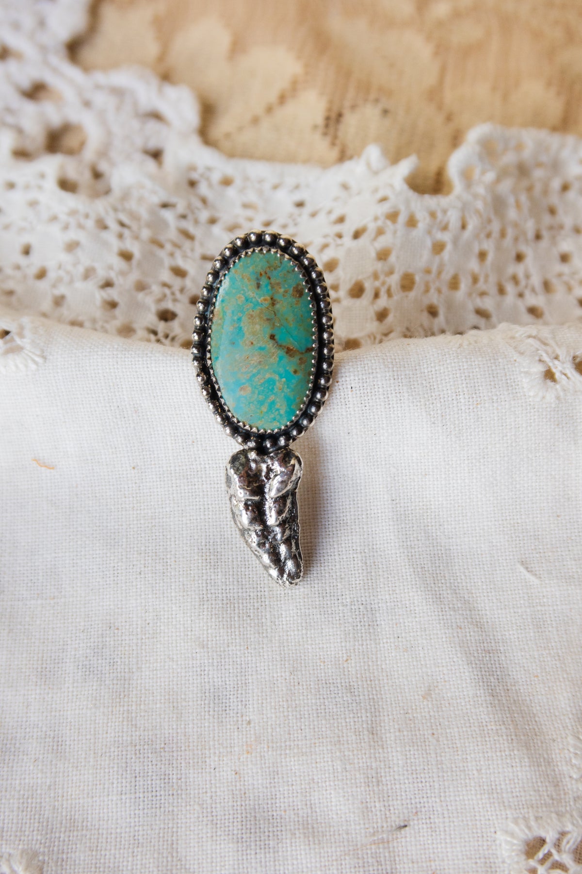 This one-of-a-kind Sterling Silver Turquoise Rattler Ring is handcrafted in the heart of South Texas. This whimsical beauty features a striking double ring shank design that wraps around your finger like a coiled serpent, crowned with genuine Kingman turquoise that captures the wild spirit of the south Texas Terrain. Each piece is uniquely crafted, making it a treasure that's as individual as you are.&nbsp;