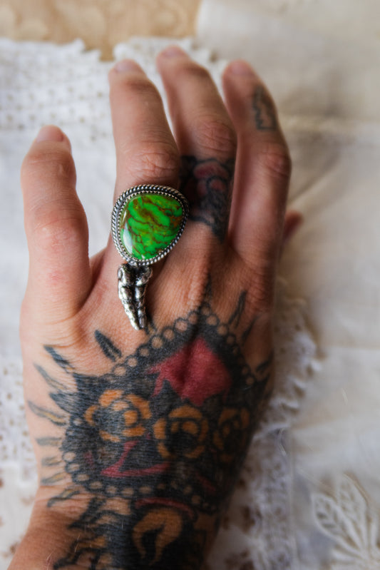 This one-of-a-kind Sterling Silver Kingman Turquoise Rattler Ring is handcrafted in the heart of South Texas. This whimsical beauty features a striking double ring shank design that wraps around your finger like a coiled serpent, crowned with genuine Kingman turquoise that captures the wild spirit of the south Texas Terrain. Each piece is uniquely crafted, making it a treasure that's as individual as you are.&nbsp;