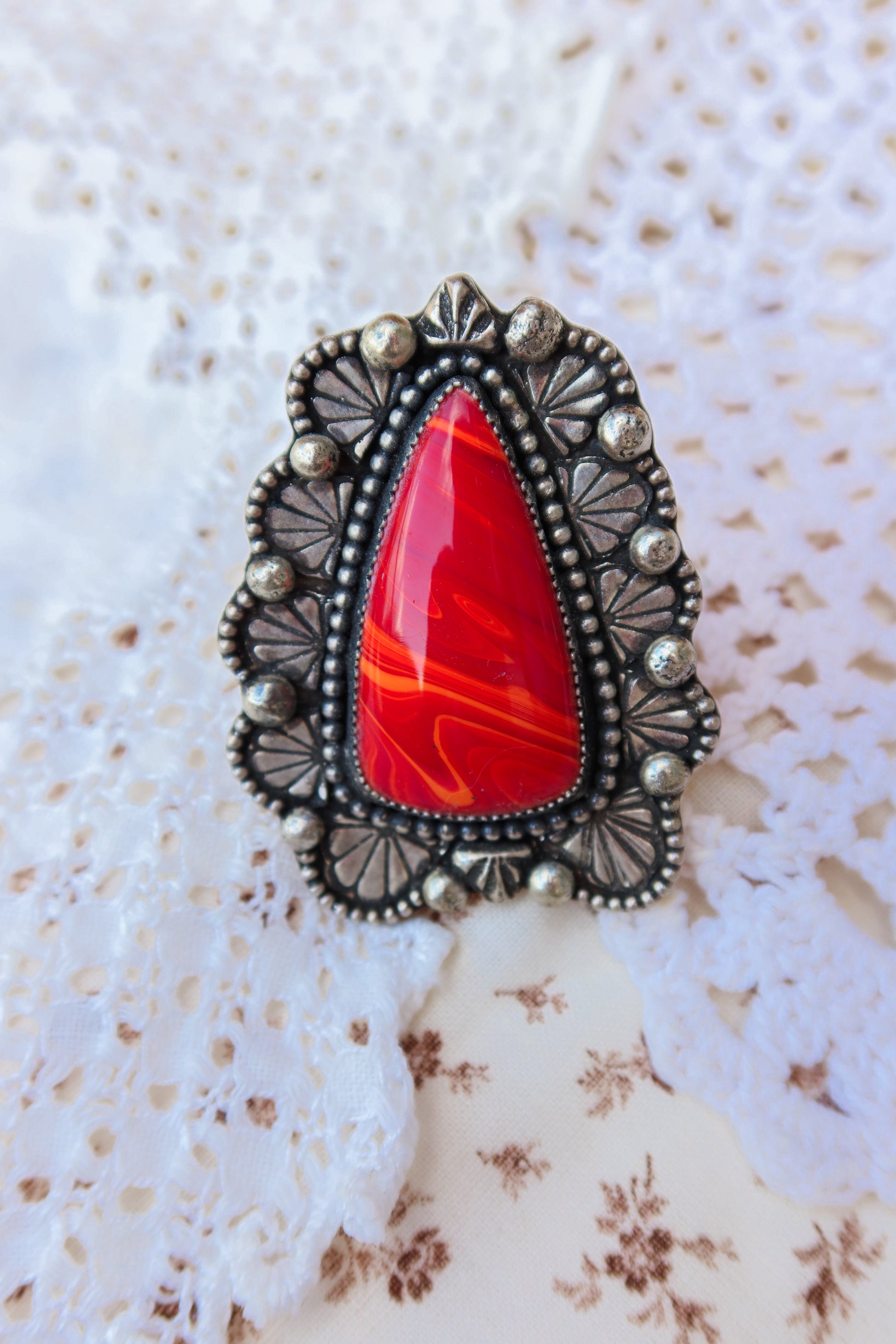 Handcrafted sterling silver ring size 7 1/4 featuring Rosarita stone accented with sand cast ornaments and stamped border. Perfect for those who appreciate one-of-a-kind jewelry with authentic craftsmanship. A versatile statement piece that works for everyday wear or special occasions.