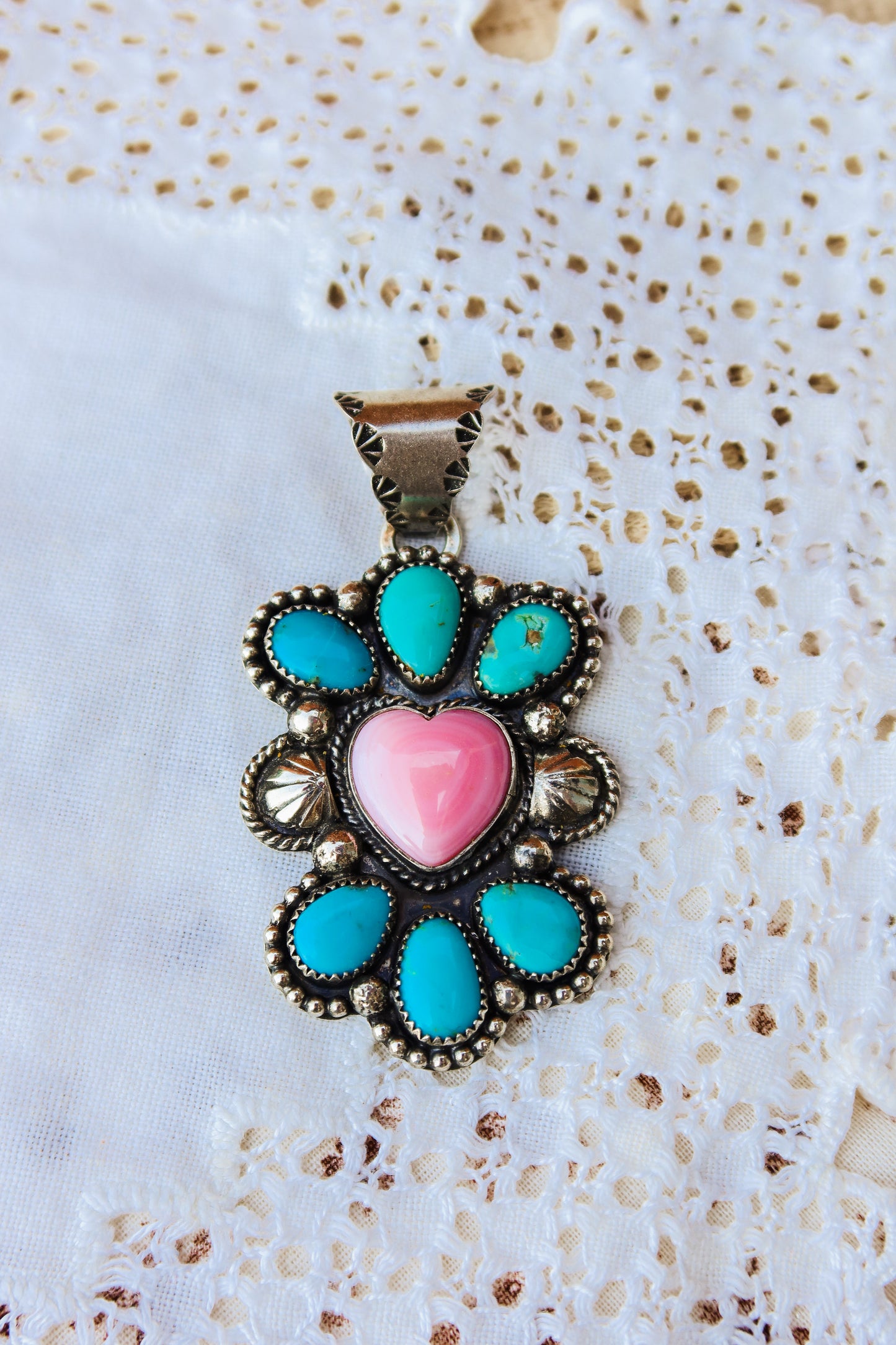Handcrafted sterling silver pendant featuring vibrant Sonoran turquoise and delicate pink conch shell. Custom handmade sterling silver bale that will fit a variety of silver bead sizes. Perfect for layering or wearing as a standalone statement piece.