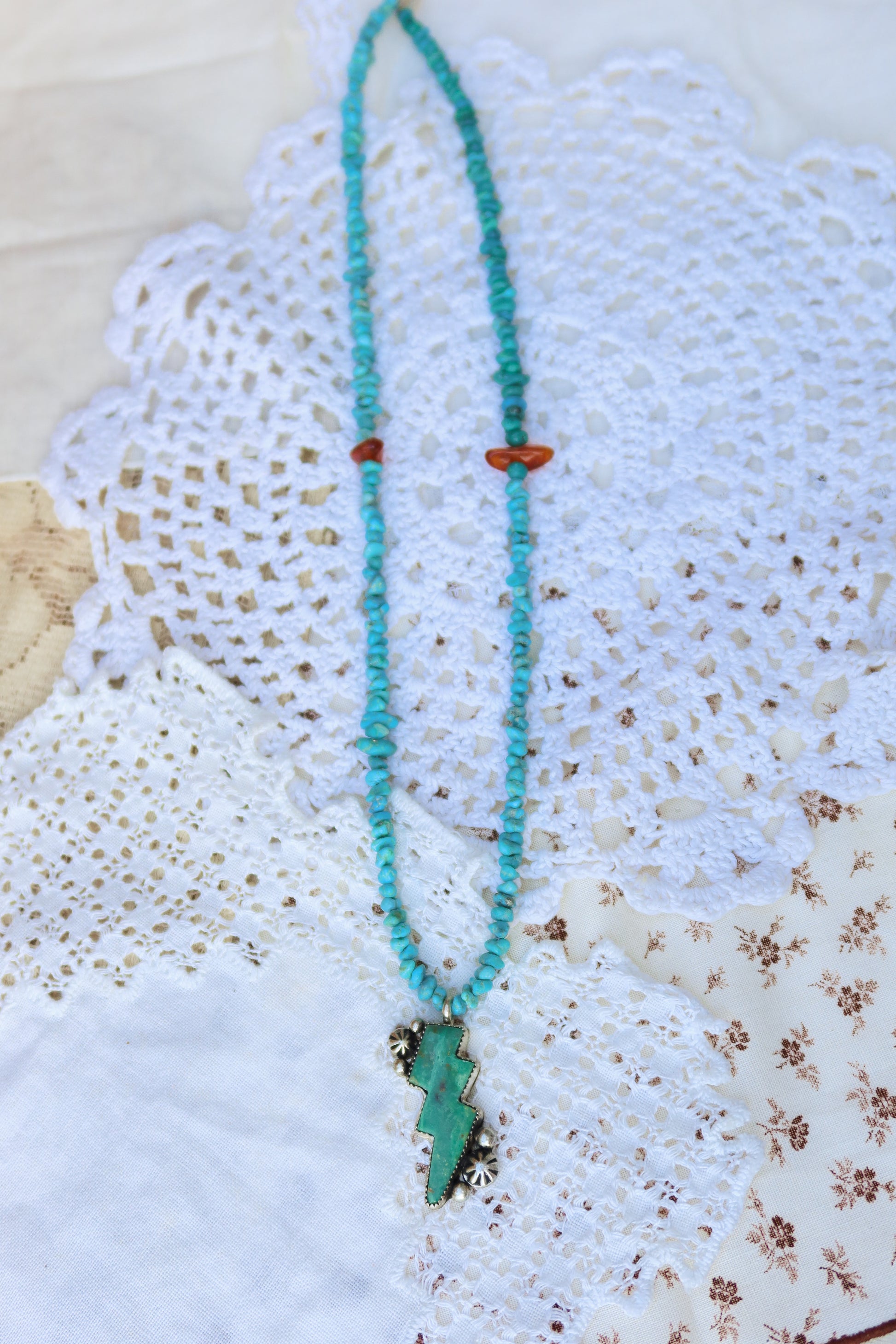 Hand-strung with Kingman turquoise and baltic amber beads, this fun necklace captures nature's electric spirit through a striking Green Kingman turquoise lightning bolt pendant. A whimsical yet refined piece that brings celestial energy to any collection.