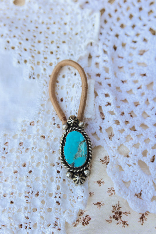 Elevate your everyday style with this stunning hair tie featuring genuine Sonoran turquoise with sterling silver ornaments. Available in three versatile options to match your look: Black, Brown, or blonde. Perfect for securing your hair while making a statement.