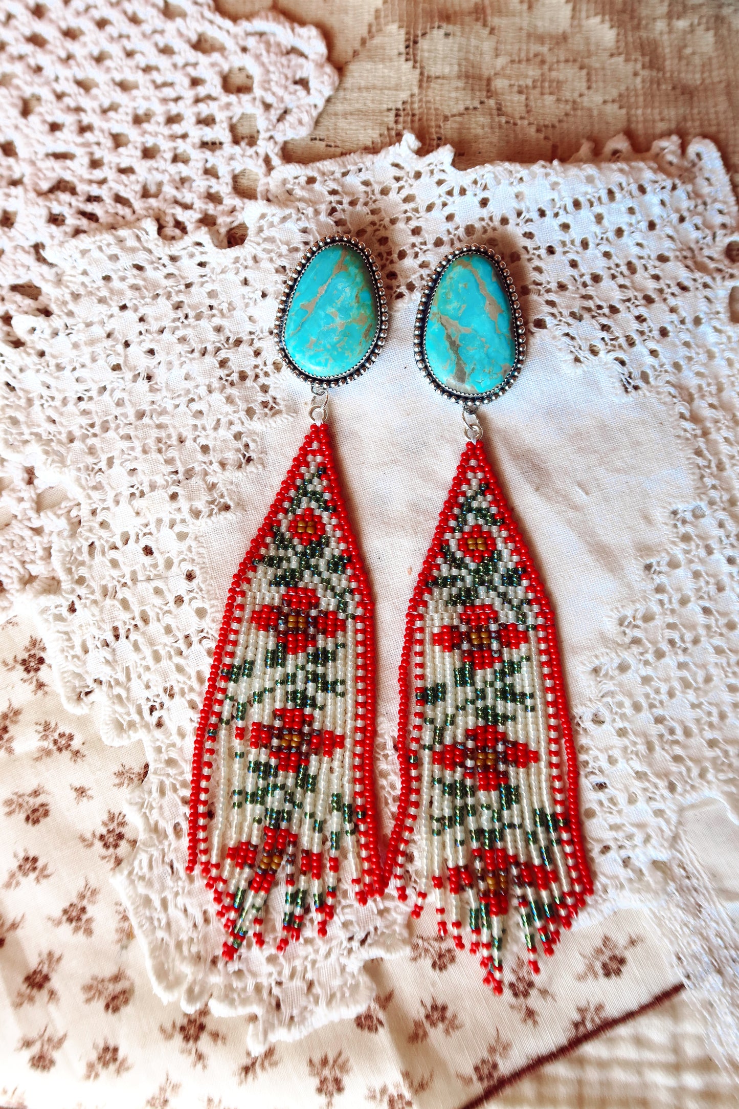 Bloom where you're beaded! These whimsical Sterling Silver and Turquoise Beaded Floral Earrings bring a touch of Southwestern charm to your everyday style. Each pair is meticulously hand-beaded with vibrant turquoise stones, creating delicate floral designs that dance with every movement. Handcrafted with love in South Texas, these earrings are a celebration of uniqueness and eccentric style. Perfect for adding a pop of color and personality to any outfit.