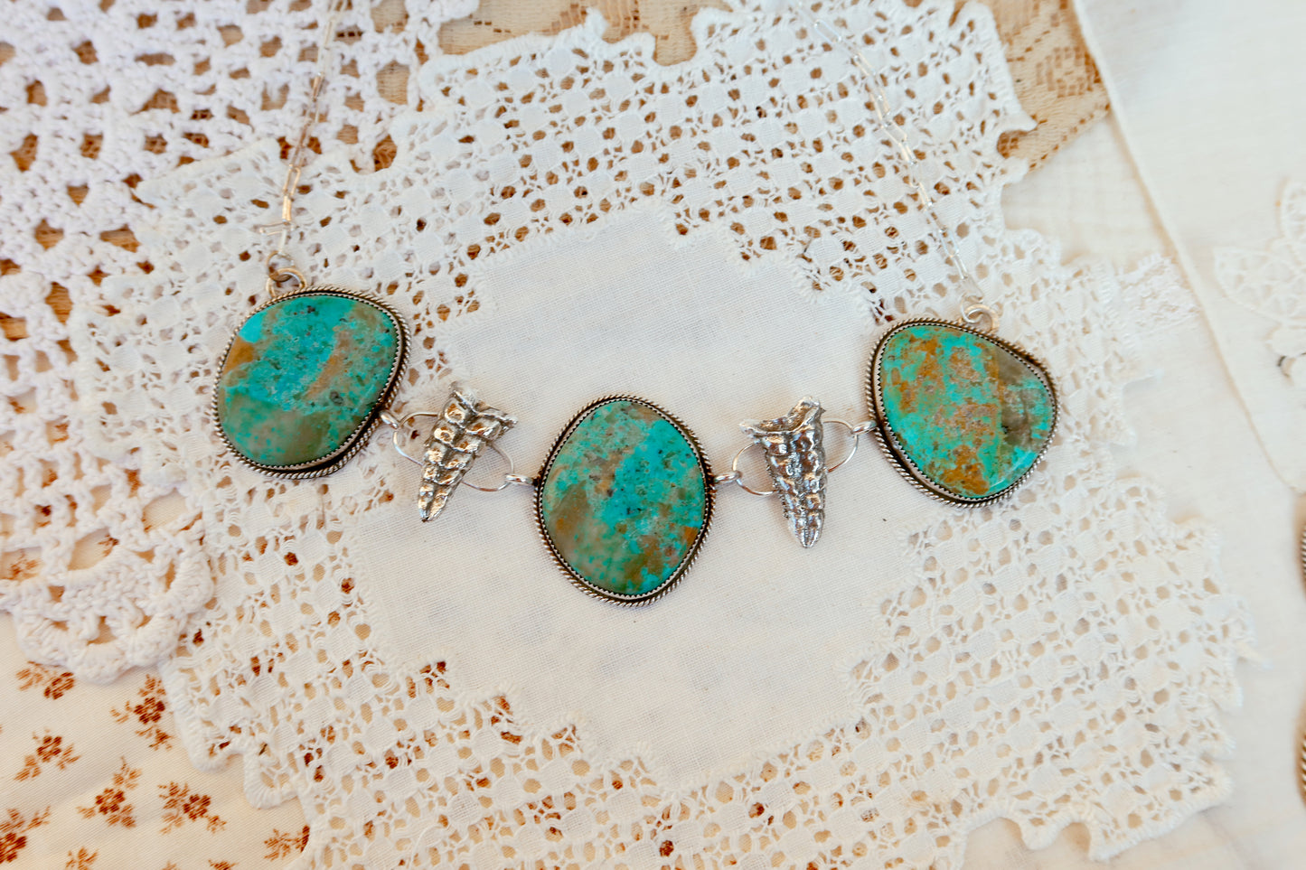 As seen on Ella Langley, shake things up with this whimsical Kingman Turquoise Sterling Silver Rattler choker—a bold statement piece that's equal parts charm and character. Handcrafted right here in South Texas, this beauty features stunning Kingman turquoise paired with sterling silver Rattlesnake rattlers sourced from South Texas. Whether you're channeling your inner whimsy or just love jewelry with personality, this rattler choker is the perfect conversation starter. Wear it proud and let your style shin