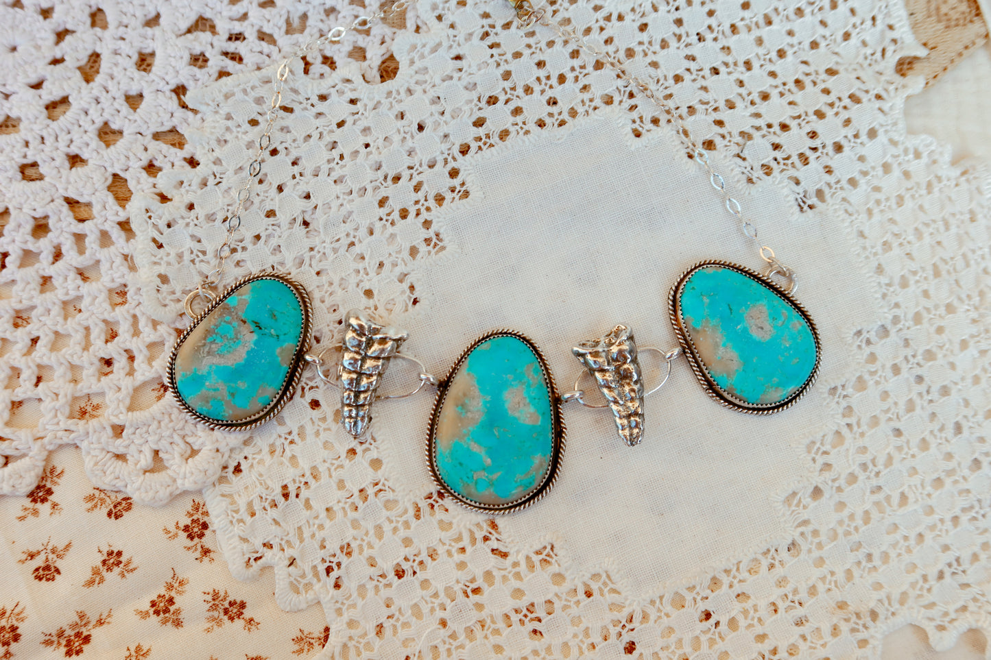 As seen on Ella Langley, shake things up with this whimsical Kingman Turquoise Sterling Silver Rattler choker—a bold statement piece that's equal parts charm and character. Handcrafted right here in South Texas, this beauty features stunning Kingman turquoise paired with sterling silver Rattlesnake rattlers sourced from South Texas. Whether you're channeling your inner whimsy or just love jewelry with personality, this rattler choker is the perfect conversation starter. Wear it proud and let your style shin