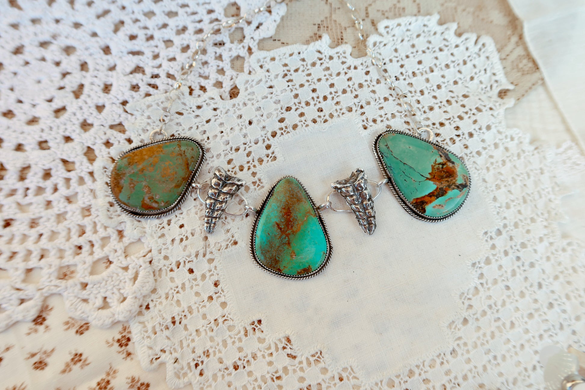 As seen on Ella Langley, shake things up with this whimsical Kingman Turquoise Sterling Silver Rattler choker—a bold statement piece that's equal parts charm and character. Handcrafted right here in South Texas, this beauty features stunning Kingman turquoise paired with sterling silver Rattlesnake rattlers sourced from South Texas. Whether you're channeling your inner whimsy or just love jewelry with personality, this rattler choker is the perfect conversation starter. Wear it proud and let your style shin