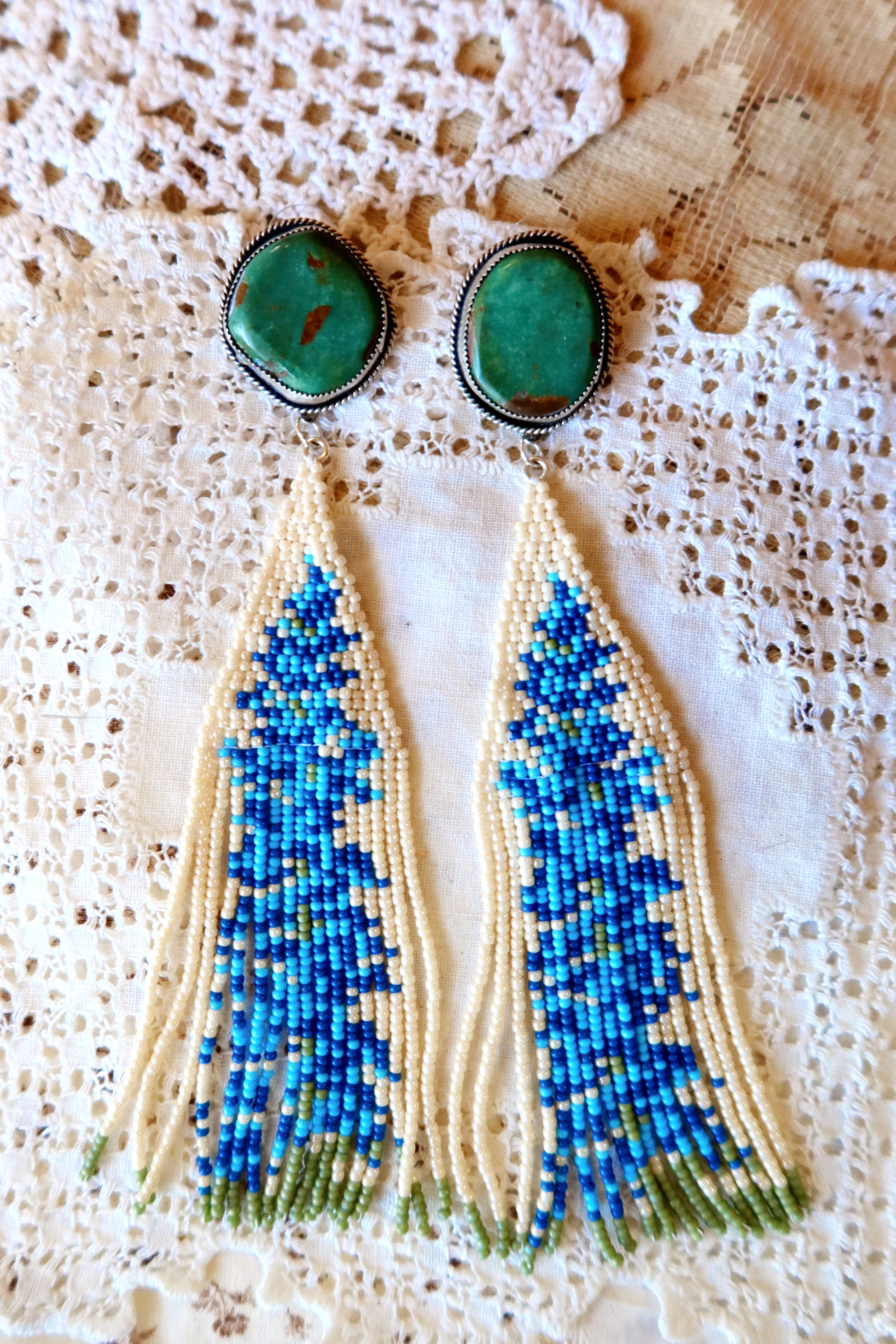 Bloom where you're beaded! These whimsical Sterling Silver and Turquoise Beaded Floral Earrings bring a touch of Southwestern charm to your everyday style. Each pair is meticulously hand-beaded with vibrant turquoise stones, creating delicate floral designs that dance with every movement. Handcrafted with love in South Texas, these earrings are a celebration of uniqueness and eccentric style. Perfect for adding a pop of color and personality to any outfit.