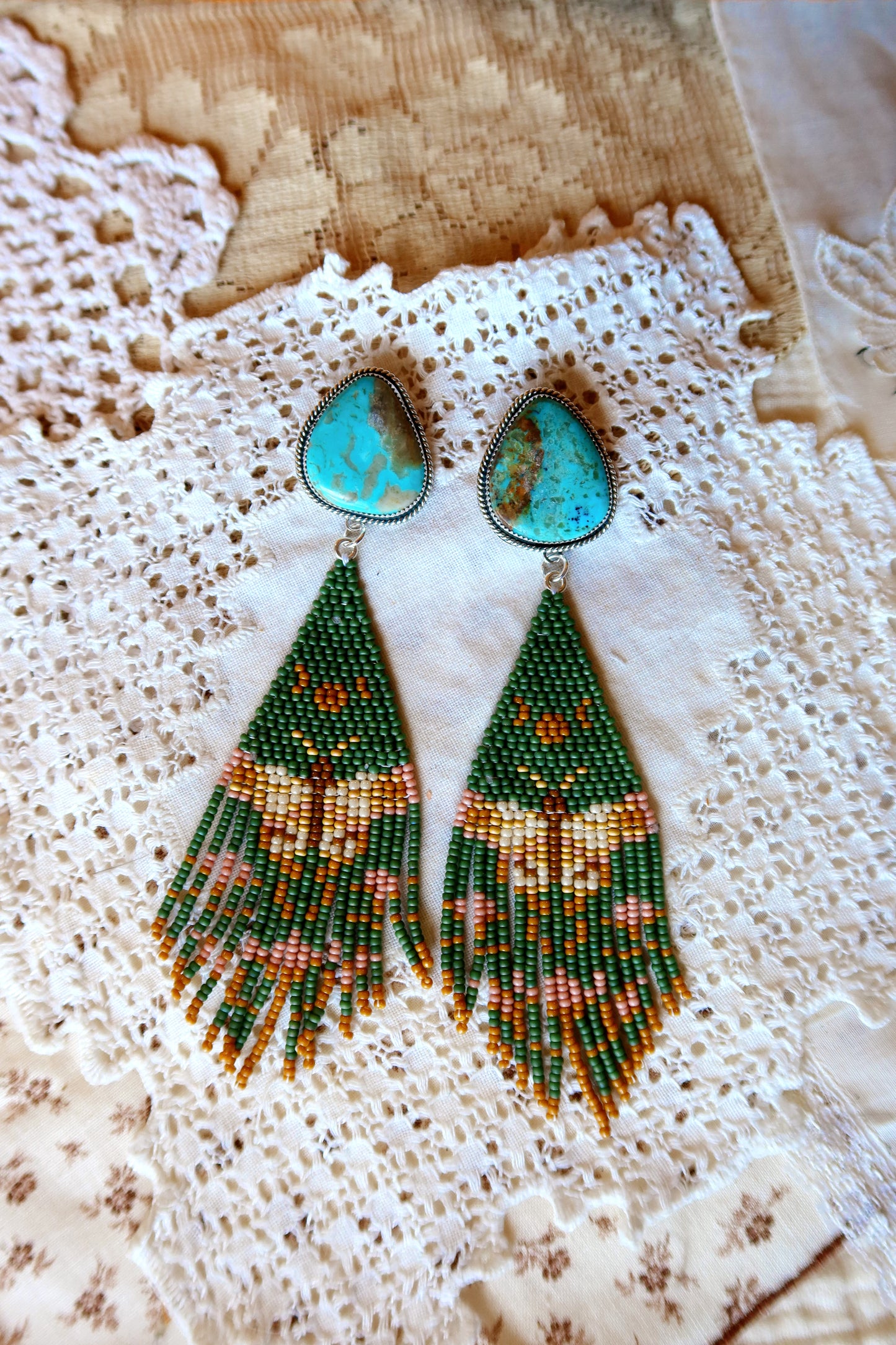 Bloom where you're beaded! These whimsical Sterling Silver and Turquoise Beaded moth Earrings bring a touch of Southwestern charm to your everyday style. Each pair is meticulously hand-beaded with vibrant turquoise stones, creating delicate floral designs that dance with every movement. Handcrafted with love in South Texas, these earrings are a celebration of uniqueness and eccentric style. Perfect for adding a pop of color and personality to any outfit.