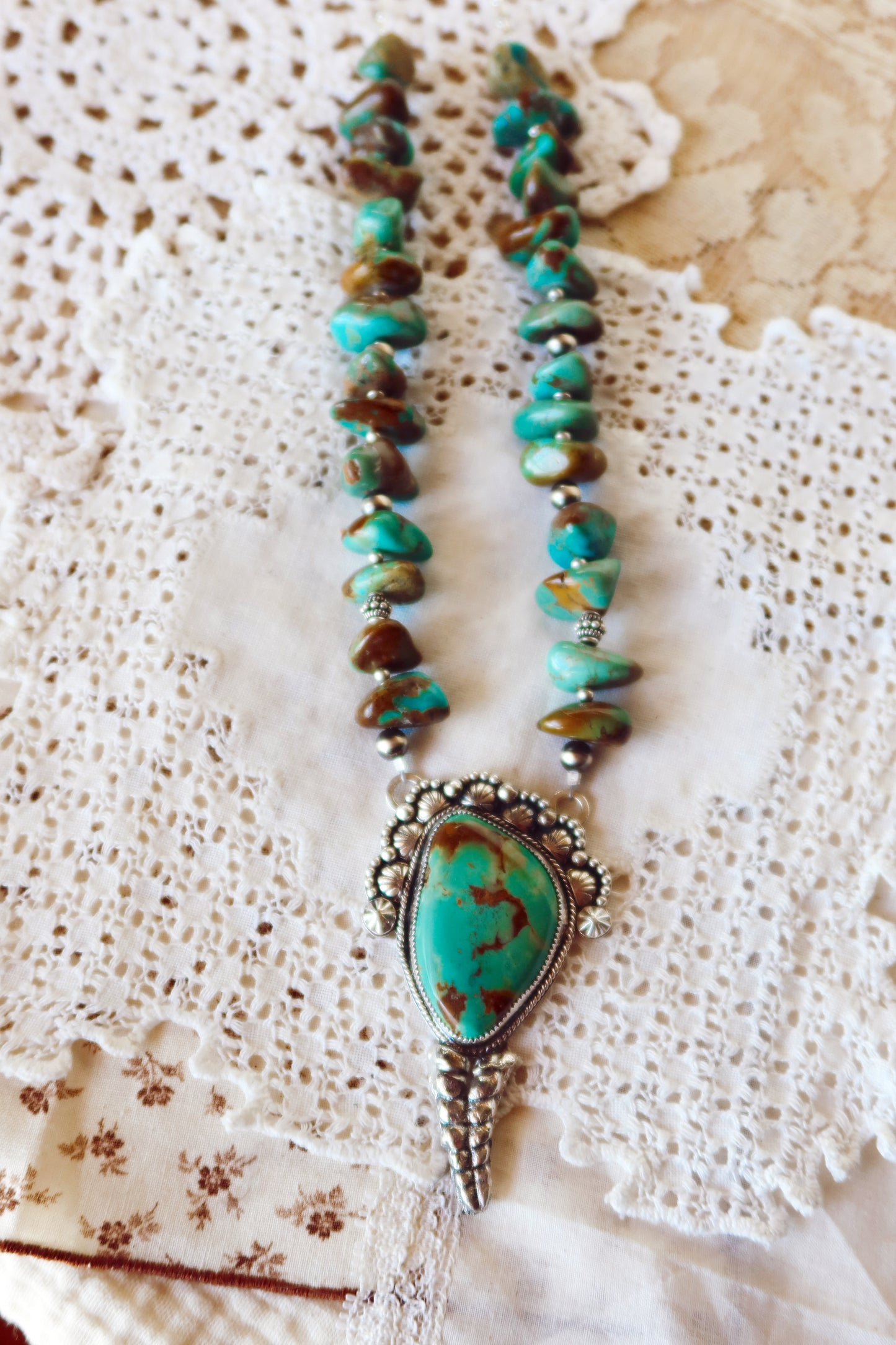  Shake things up with this whimsical LARGE Kingman Turquoise Sterling Silver Rattler Pendant—a bold statement piece that's equal parts charm and character. Handcrafted right here in South Texas, this beauty features stunning Kingman turquoise paired with delicate Chinese turquoise beads and sterling silver accents that catch the light beautifully. Whether you're channeling your inner whimsy or just love jewelry with personality, this rattler pendant is the perfect conversation starter. Wear it proud and let