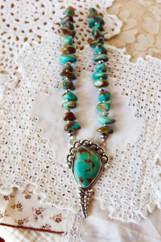  Shake things up with this whimsical LARGE Kingman Turquoise Sterling Silver Rattler Pendant—a bold statement piece that's equal parts charm and character. Handcrafted right here in South Texas, this beauty features stunning Kingman turquoise paired with delicate Chinese turquoise beads and sterling silver accents that catch the light beautifully. Whether you're channeling your inner whimsy or just love jewelry with personality, this rattler pendant is the perfect conversation starter. Wear it proud and let