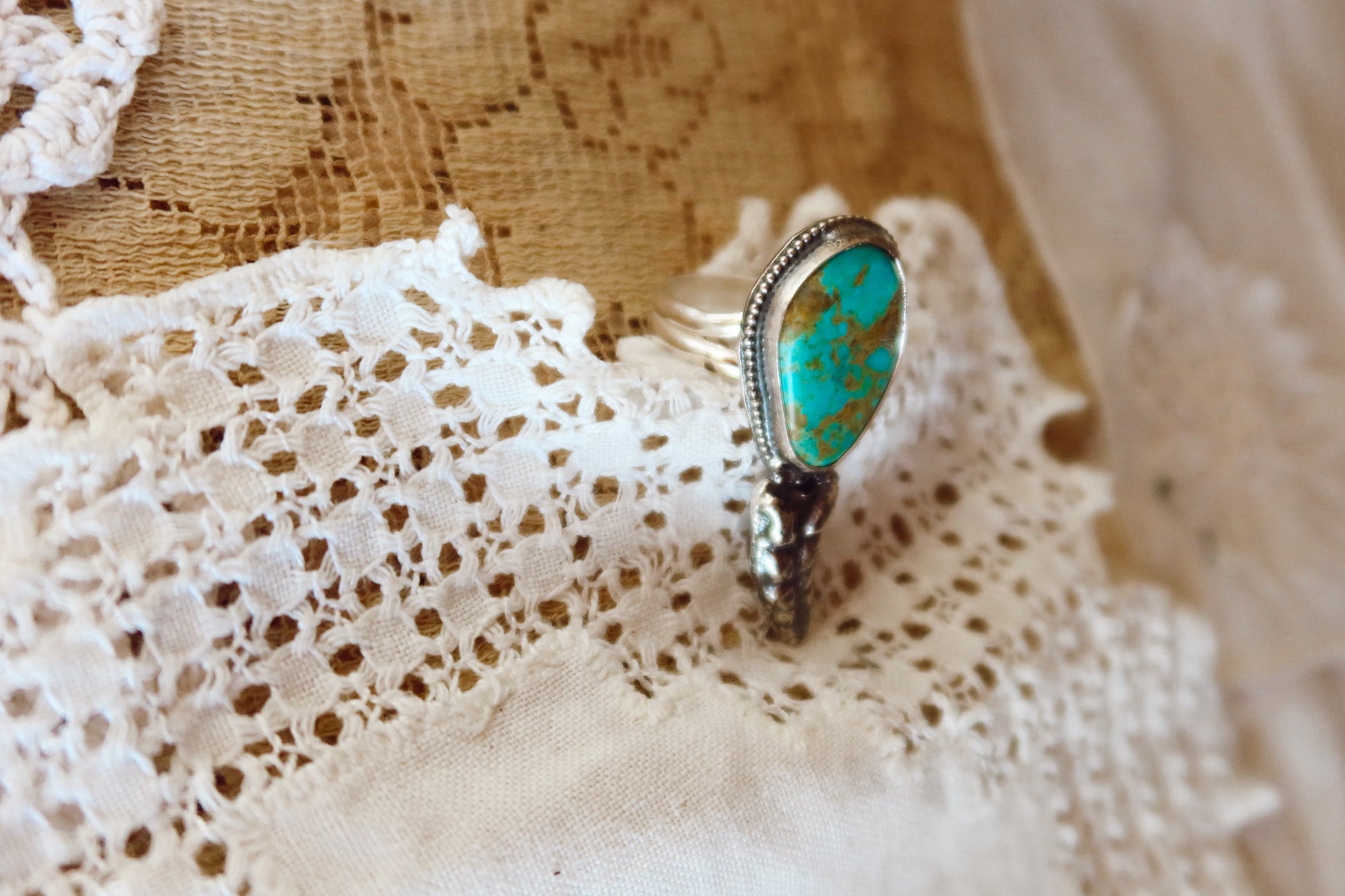 This one-of-a-kind Sterling Silver Kingman Turquoise Rattler Ring is handcrafted in the heart of South Texas. This whimsical beauty features a striking double ring shank design that wraps around your finger like a coiled serpent, crowned with genuine Kingman turquoise that captures the wild spirit of the south Texas Terrain. Each piece is uniquely crafted, making it a treasure that's as individual as you are.