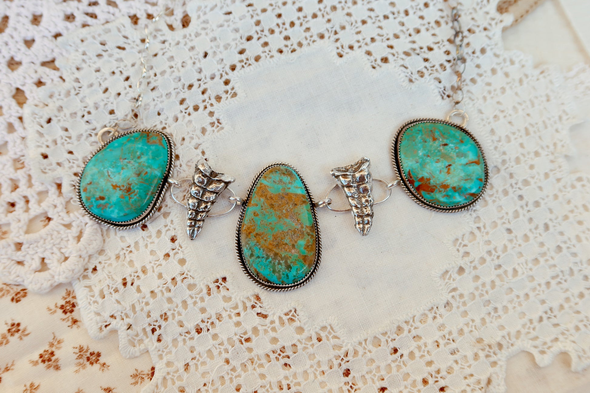 As seen on Ella Langley, shake things up with this whimsical Kingman Turquoise Sterling Silver Rattler choker—a bold statement piece that's equal parts charm and character. Handcrafted right here in South Texas, this beauty features stunning Kingman turquoise paired with sterling silver Rattlesnake rattlers sourced from South Texas. Whether you're channeling your inner whimsy or just love jewelry with personality, this rattler choker is the perfect conversation starter. Wear it proud and let your style shin